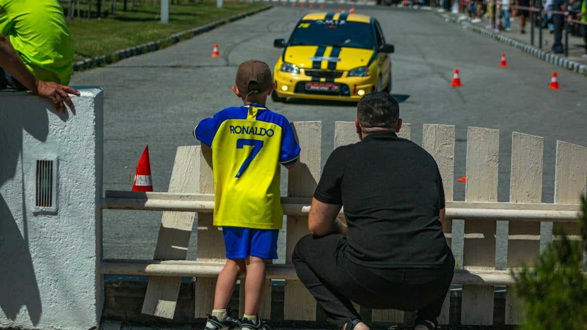 People watch a yellow car race on a track
