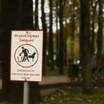 A sign that is on a pole in the grass